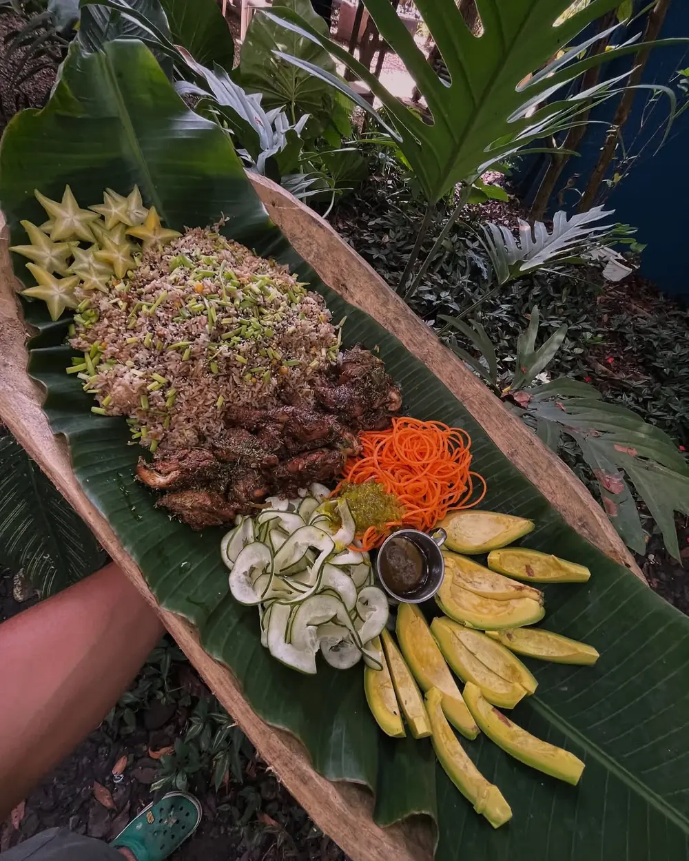 Banquete dominicano servido sobre una hoja de plátano en el campo