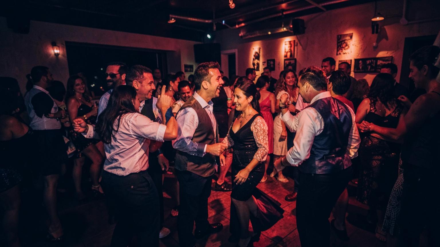 Parejas bailando en una pista llena de noche